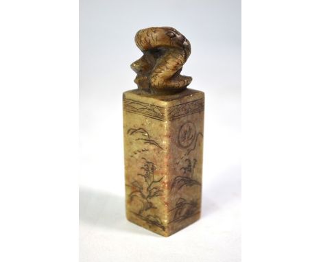 A Chinese soapstone seal with curled snake finial, each of the four sides decorated with a mountainous landscape, 8 cm high, 