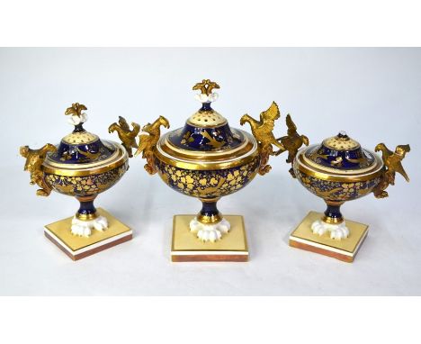 An early 19th century Continental porcelain garniture set of three pot pourri vases and covers, with finely gilded floral, fo