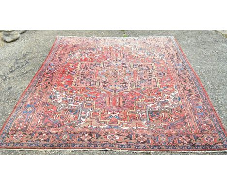 A Persian Heriz carpet, last quarter 20th century, the large central rosette medallion and stylized floral design within repe