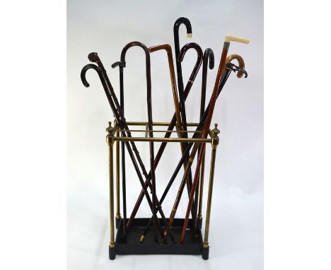 A brass six division stick stand with cast iron base to/w an assortments of sticks (11)