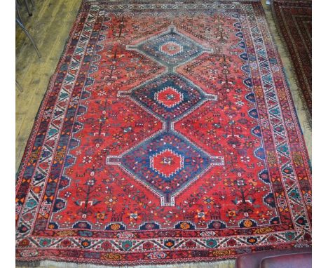 A Persian Shiraz carpet, the red ground with stylised centre medallion, 3.02 m x 2.15 m