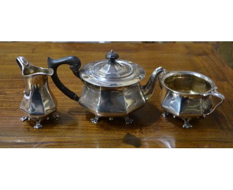 An Edwardian Art Nouveau style silver bachelor tea service of octagonal form, the jug and basin with whiplash handles and 'or