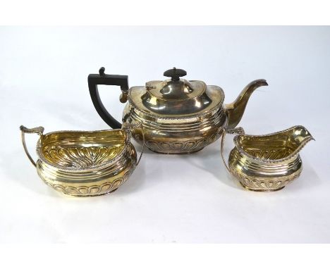 An Edwardian heavy quality silver three piece tea service in the Regency manner, with lobed half-reeding, James Deakin &amp; 