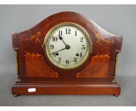 A mantel clock with inlaid decoration, Arabic numerals to a silvered dial, approximately 28 cm (h).