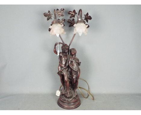 A large, twin light, figural table lamp with pink glass shades, approximately 77 cm (h).Lot descriptions reflect the catalogu