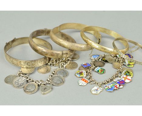 FIVE BANGLES AND TWO BRACELETS to include four hinged bangles, a belcher link charm bracelet suspending enamel tourist charms