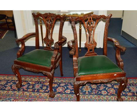 A PAIR OF REPRODUCTION CARVED MAHOGANY CHIPPENDALE STYLE ARMCHAIRS with green leatherette drop in seat pads (2)