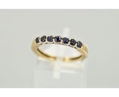 A 9CT GOLD SEVEN STONE SAPPHIRE RING, designed as a line of circular claw set sapphires, hallmark rubbed, ring size K 1/2, we