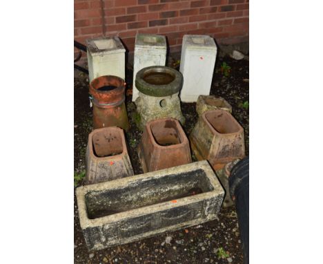 A COLLECTION OF COMPOSITE GARDEN ITEMS including three white painted columns, terracotta chimney, three terracotta plant tops