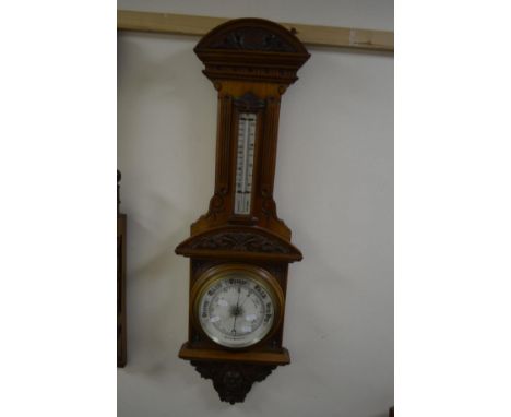 AN CARVED WALNUT ANEROID BAROMETER, with foliate moulding, approximate height 103cm