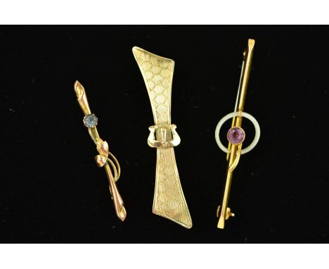 THREE EARLY 20TH CENTURY GOLD BROOCHES, the first of bow shape outline with diamond engraved pattern and central buckle detai