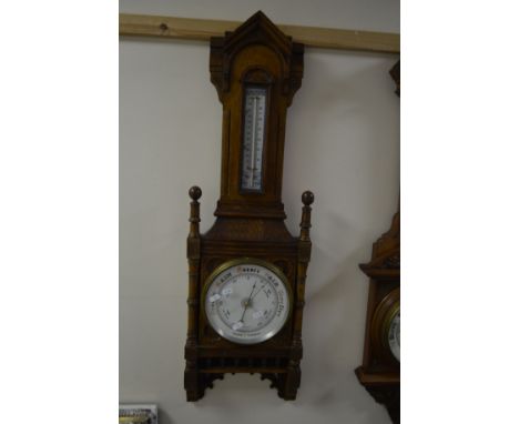AN EDWARDIAN OAK ANEROID BAROMETER, approximate width 95cm