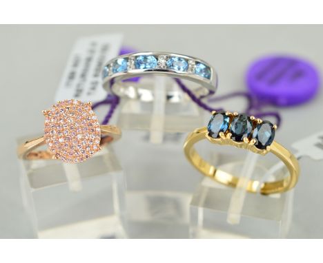 THREE GOLD GEM SET RINGS to include an 18ct yellow gold lliana three stone indicolite ring, the three oval stone within four 