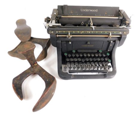 A 20thC Underwood typewriter, in black with chrome insert and articulated keys, 35cm wide, and two cobbler's anvils.  (3)