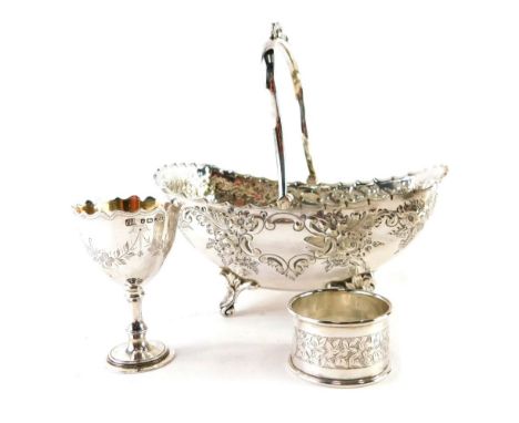 An Edwardian silver plated basket, with swing handle, repousse decorated floral and scroll body, and shaped feet, 17cm wide, 