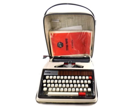 A vintage Brother Deluxe 3050 typewriter, with plastic wood effect fitting, articulated keys, in outer case, 33cm wide.