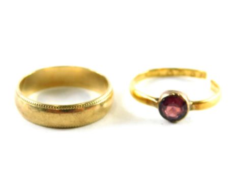 Two rings, comprising a 9ct gold wedding band with outer reeded design, ring size P and a cut band set with garnet, rubbed ha