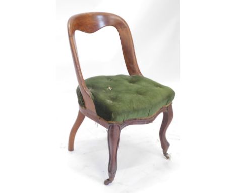 A Victorian mahogany spoon back chair, with a green upholstered padded seat on cabriole legs with castors. 