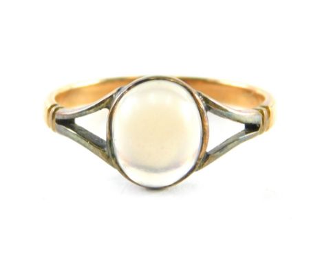 A moonstone dress ring, the oval moonstone in a rubover white gold setting with V splayed shoulders and yellow metal band, wi