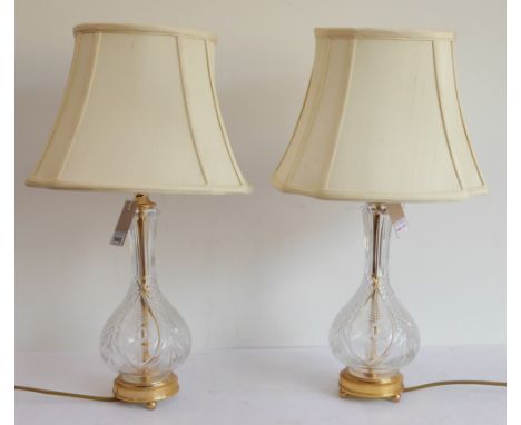 A pair of globe and shaft style clear glass and gilt metal mounted table lamps with matching shades: the bodies finely engrav