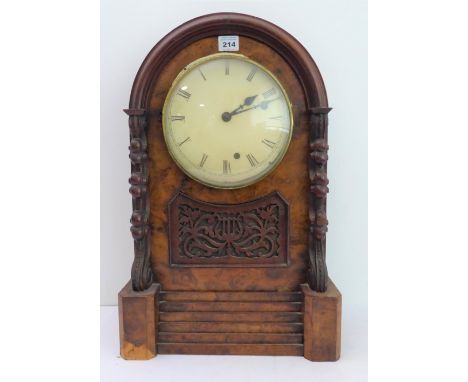 A 19th century walnut cased mantle clock: cream dial with Roman numerals, the movement striking on a gong, two carved columns