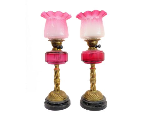A fine and rare pair of 19th century brass, marble and cranberry glass oil lamps: the crimped-edge etched shades above facete