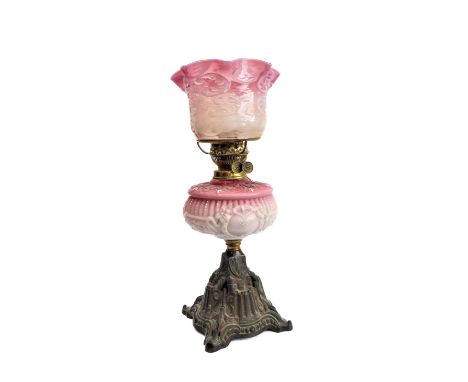 A 19th century brass opaline glass and cast-iron oil lamp: the crimped-edge cranberry and opaline-style shade above an elabor