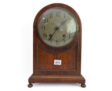 An early 20th century dome-topped oak-cased eight-day mantle clock: the silvered dial with Arabic numerals, striking movement