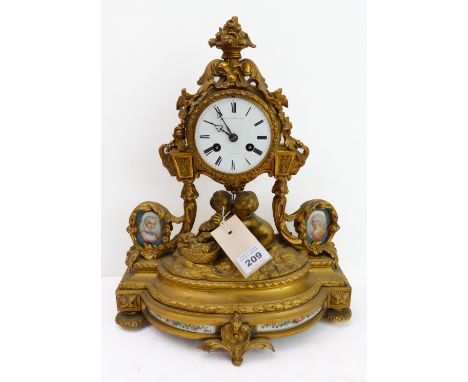 A fine 19th century gilt-metal and porcelain mounted eight-day mantle clock: the floral surmount above a white enamel dial wi