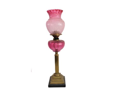 A 19th century brass, marble and cranberry glass oil lamp: the thistle-shaped crimped edge shade above a cranberry reservoir 