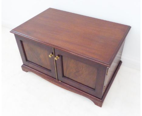 A mahogany side-cabinet: thumbnail moulded top; two finely figured mahogany panelled doors opening to reveal a shelf and a fu