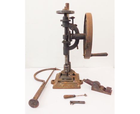 A large and heavy pillar drill: hand operated with a wooden handle on a wheel mechanism, together with various other tools in