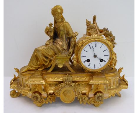 A 19th century gilt-metal eight-day figural mantle clock: the white enamel dial with Roman numerals and below an anchor and r