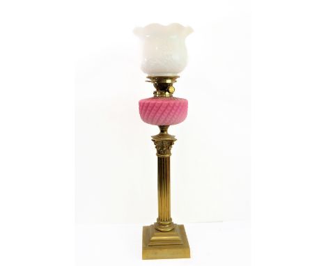 A 19th century brass and opaline glass oil lamp: the white glass crimped-edge top decorated in relief with flowerheads and ot