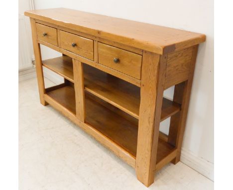 A fine and modern solid oak side unit: the cleated overhanging top above three frieze drawers and shelf space below, raised o