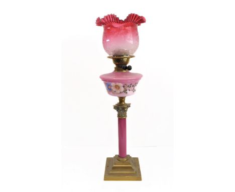 A 19th century brass and cranberry glass oil lamp: the crimped-edge etched shade above a circular tapering glass reservoir de