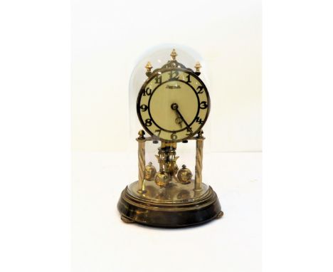 An anniversary clock under a glass dome by 'Hermle' (19cm high including glass dome)