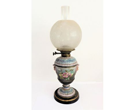A late 19th century ceramic oil lamp: spherical, etched clear-glass shade; the circular tapering body decorated with two 'mas