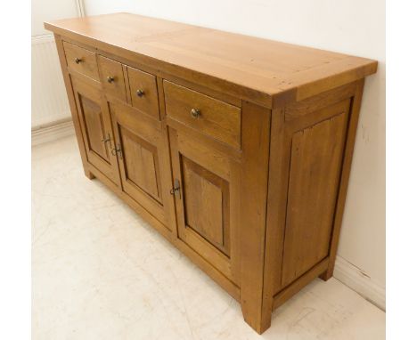 15 A fine solid heavy oak sideboard: the cleated overhanging top above an arrangement of three frieze drawers and three field