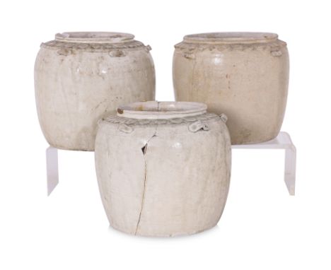 A GROUP OF THREE VIETNAMESE WHITE GLAZED JARS
13th-14th century, cylindrical jars in pale transparent celadon green glaze, ca