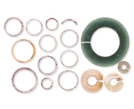 A GROUP OF VIETNAMESE SLIT RINGS AND BRACELET
Circa 3rd century AD, a green glass slit form bracelet, two jade examples, one 