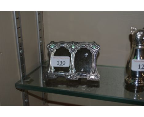 A silver and enamel decorated double photo frame 