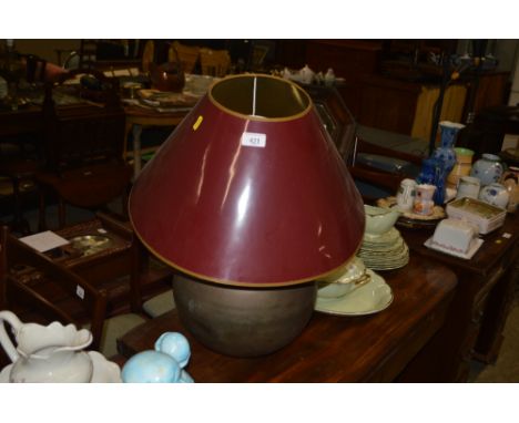 A large brass table lamp with red shade