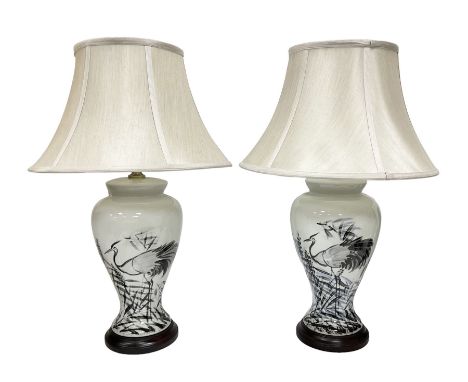 Pair of table lamps of tapering form, decorated with herons wading amongst reeds, on a white ground, with a circular footed b