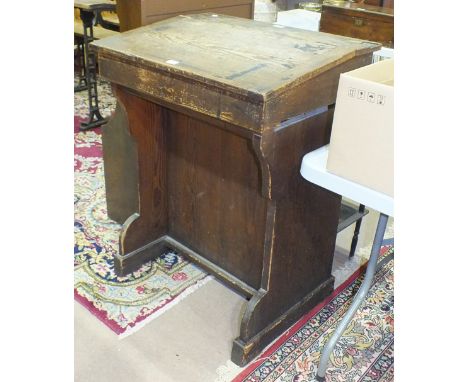*A school master's vintage pine desk, the hinged sloping desk top and inkwell aperture with metal slide, above a pair of pane