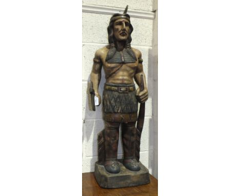 A carved wooden figure of a Red Indian holding a tomahawk and bow and carrying a quiver on his back, 103cm high overall, (pos