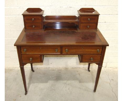 An early-20th century inlaid and cross-banded mahogany lady's writing desk, the top with four small drawers, a shelf and inse