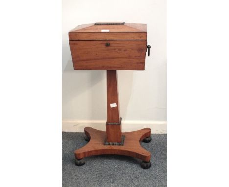 An early-19th century satinwood teapoy, the sarcophagus-shaped caddy with metal carrying handles and hinged lid enclosing thr