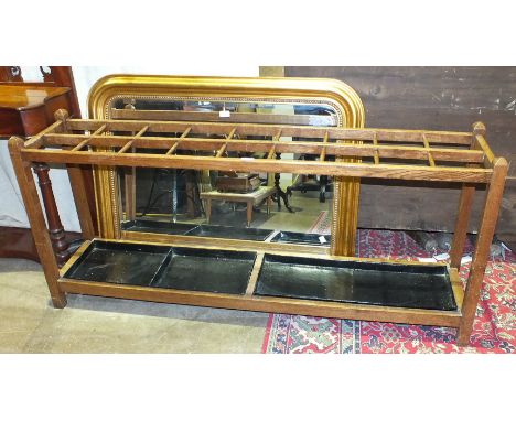A large oak umbrella stand of eighteen divisions, with two metal drip trays, 154cm long, 69cm high, a Victorian mahogany hall
