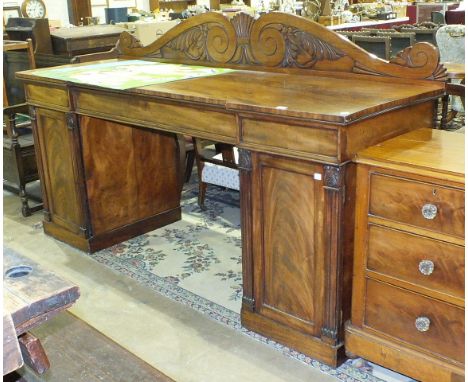 A George IV mahogany pedestal sideboard, the carved scrolling low back above three frieze drawers and a pair of panelled door